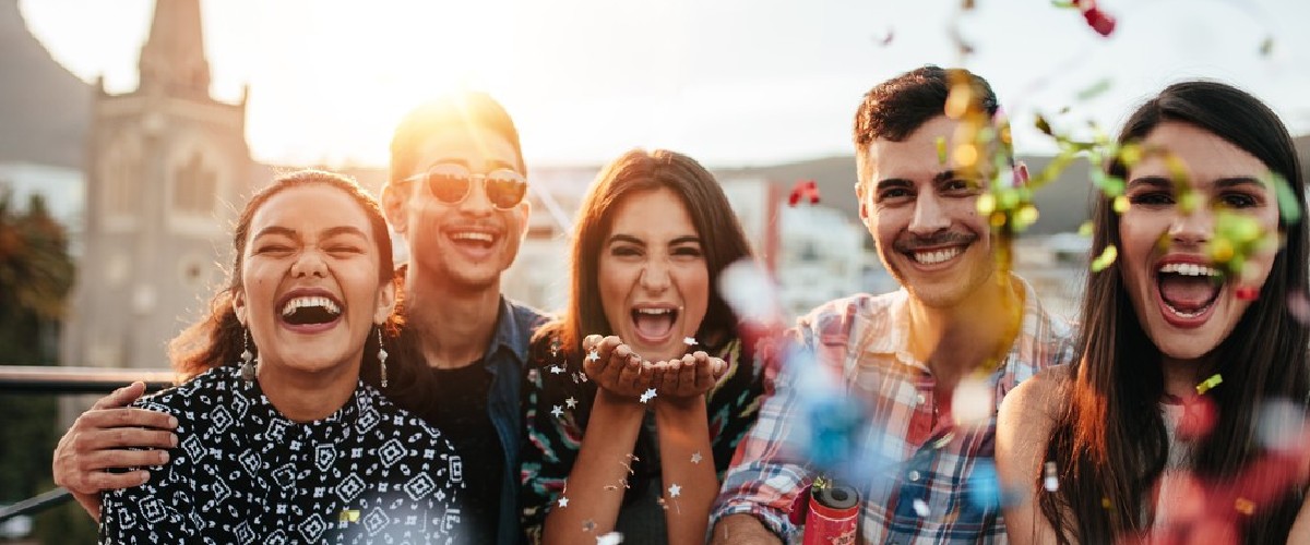 Group of women and men smiling and looking happy together.