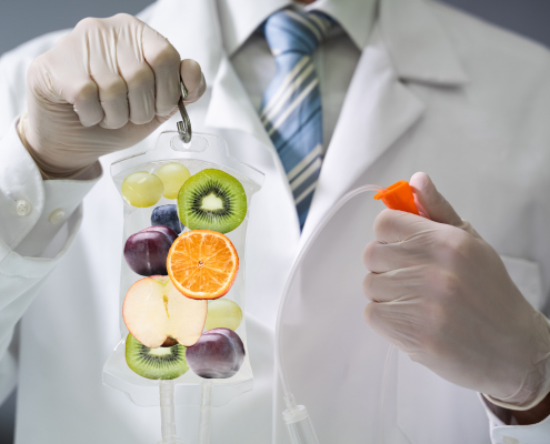 Doctor Holding Saline Bag With Fruit Slices Inside In Hospital