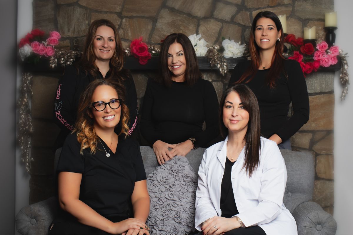 The IV Nurses team sitting on a couch in front of a fireplace.