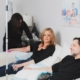 A man and a woman relax on a couch at home while receiving IV therapy from the IV Nurses, a treatment option for conditions like iv therapy for lyme disease.