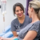 A smiling nurse administering an IV drip to a traveling woman to help skip holiday travel fatigue and treat jet lag.
